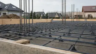 Zbrojenie płyty fundamentowej gotowe do zalania betonem. Stalowe pręty tworzą gęstą siatkę, zapewniając wytrzymałość konstrukcji.