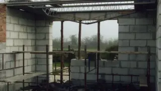 Budowa domu w toku. Widoczne zbrojenie stropu zasady, ściany z pustaków, tymczasowe podpory i rusztowania.