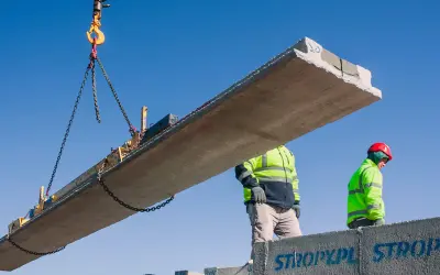 Dwa budowlańcy w kamizelkach odblaskowych montują strop Teriva. Zastanawiasz się, ile kosztuje strop Teriva na 100m2?