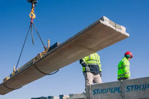 Dwa budowlańcy w kamizelkach odblaskowych montują strop Teriva. Zastanawiasz się, ile kosztuje strop Teriva na 100m2?